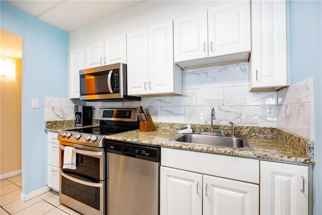 kitchen featuring light tile patterned floors, stainless steel appliances, white cabinetry, and sink