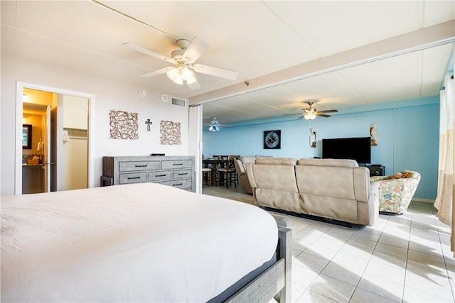 bedroom with a walk in closet, ceiling fan, a closet, and light tile patterned flooring