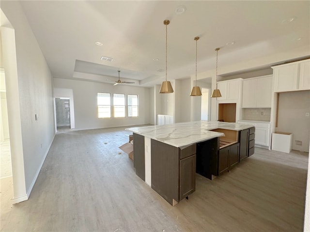 kitchen with white cabinets, ceiling fan, dark brown cabinetry, and light hardwood / wood-style flooring