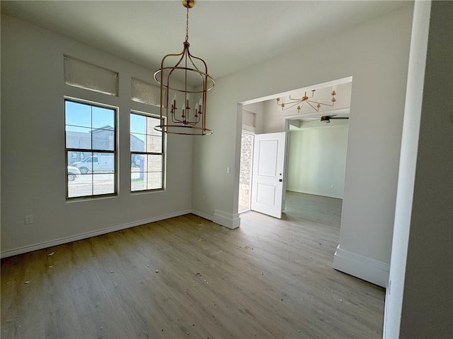 unfurnished dining area with wood-type flooring and a chandelier