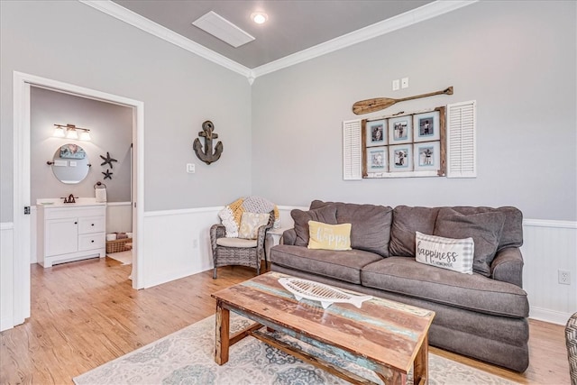 living room featuring sink, light wood-type flooring, and crown molding