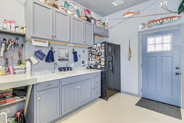 kitchen with gray cabinets, sink, and black fridge with ice dispenser