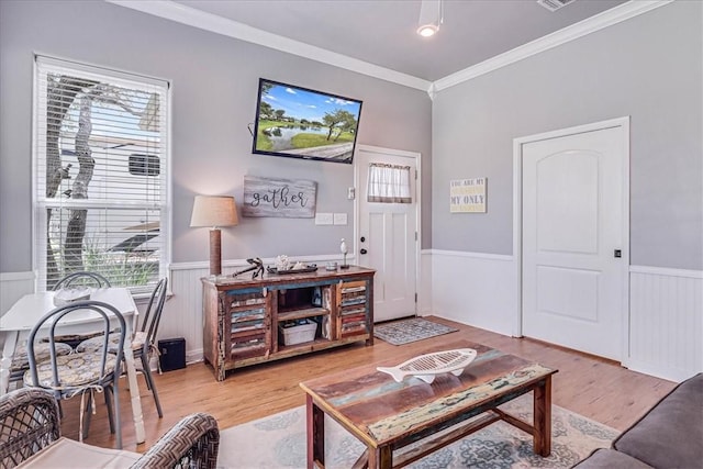 77 Augusta Cir, Aransas Pass, TX 78336 - living room with a wainscoted wall, healthy amount of natural light, ornamental molding, and light wood-style flooring