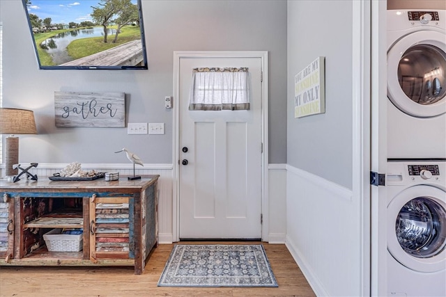 entryway featuring a healthy amount of sunlight, stacked washer and dryer, and hardwood / wood-style flooring