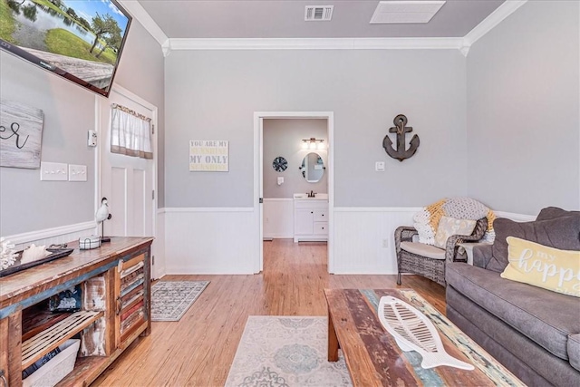 77 Augusta Cir, Aransas Pass, TX 78336 - living room featuring crown molding, light wood finished floors, and wainscoting
