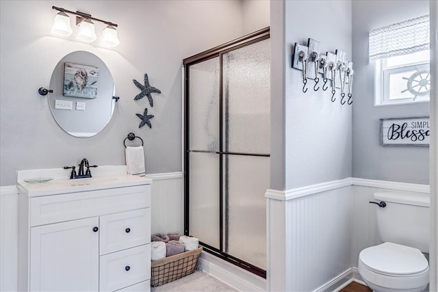 bathroom with walk in shower, vanity, and toilet