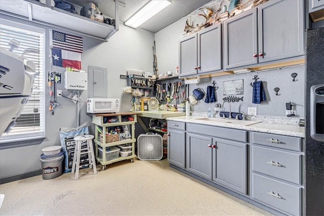 kitchen with gray cabinets, electric panel, and sink