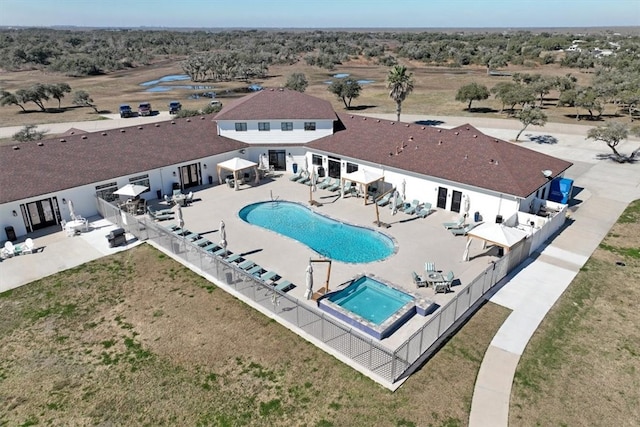 view of pool featuring a lawn, a patio, and an in ground hot tub