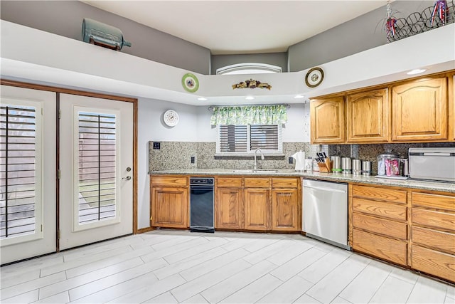 441 Colony Dr, Corpus Christi, TX 78412 - kitchen featuring brown cabinetry, tasteful backsplash, stainless steel dishwasher, light stone countertops, and a sink