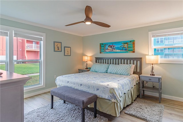 bedroom featuring crown molding, light hardwood / wood-style floors, and ceiling fan