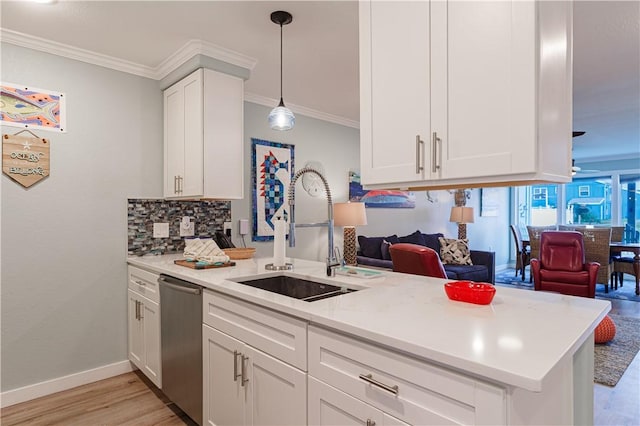 kitchen with pendant lighting, dishwasher, sink, white cabinets, and kitchen peninsula