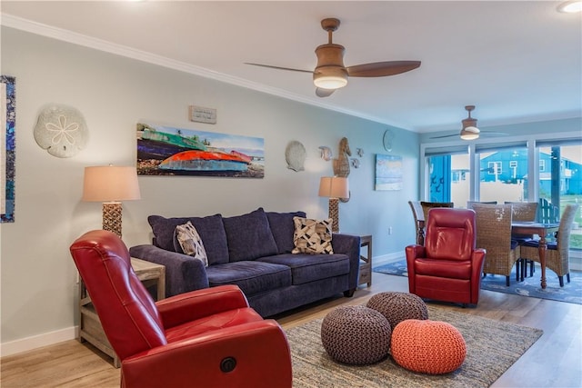 living room with ceiling fan, ornamental molding, and light wood-type flooring