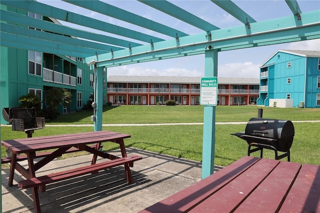 view of community featuring a yard and a pergola