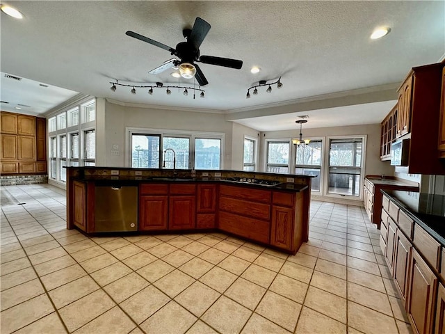 kitchen with a textured ceiling, light tile patterned flooring, stainless steel appliances, a sink, and dark countertops