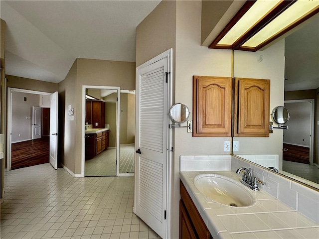 bathroom with tile patterned floors, baseboards, and vanity