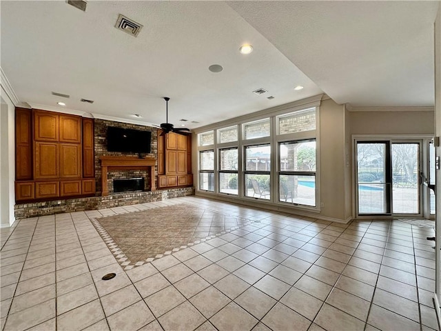 unfurnished living room featuring a brick fireplace, ornamental molding, a ceiling fan, and light tile patterned flooring