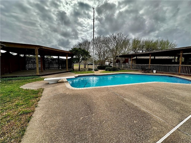 view of pool featuring a patio, fence, a diving board, a wooden deck, and a fenced in pool