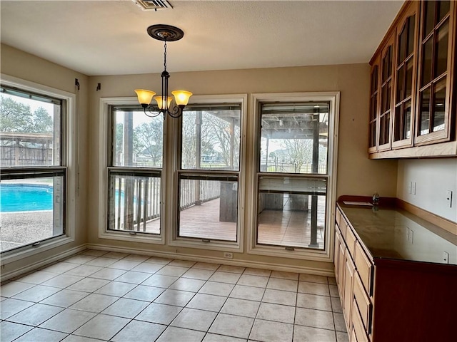 unfurnished dining area featuring visible vents, a notable chandelier, and light tile patterned floors