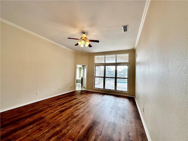 unfurnished room featuring dark wood-style floors, crown molding, visible vents, and baseboards