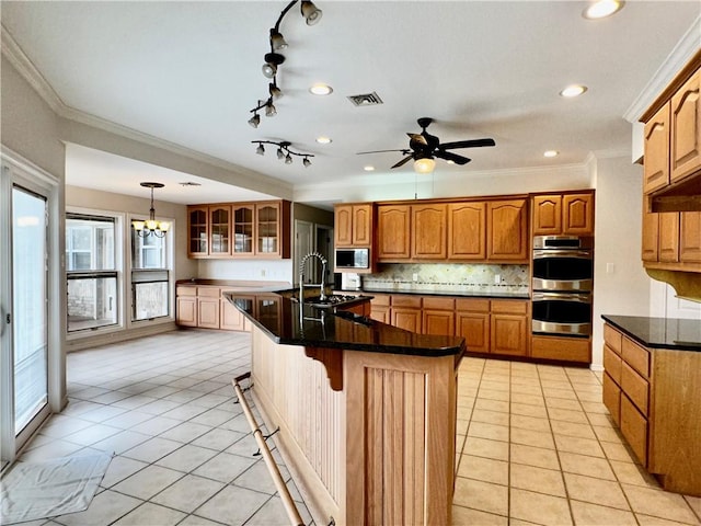 kitchen with light tile patterned floors, stainless steel appliances, visible vents, and decorative backsplash