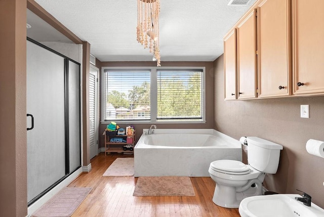 256 Melrose St, Corpus Christi, TX 78404 - bathroom with a bidet, a stall shower, a garden tub, wood-type flooring, and a textured ceiling