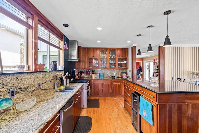 256 Melrose St, Corpus Christi, TX 78404 - kitchen featuring dishwasher, stove, tasteful backsplash, light wood-type flooring, and wall chimney exhaust hood