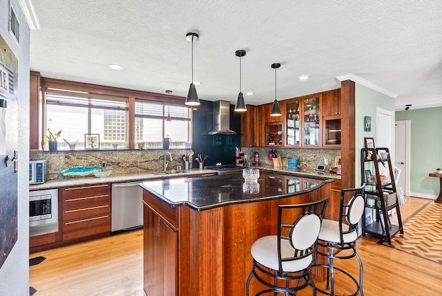 256 Melrose St, Corpus Christi, TX 78404 - kitchen featuring stainless steel appliances, wall chimney range hood, light wood-type flooring, decorative backsplash, and a textured ceiling