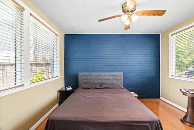 256 Melrose St, Corpus Christi, TX 78404 - bedroom with brick wall, wood finished floors, ceiling fan, and an accent wall