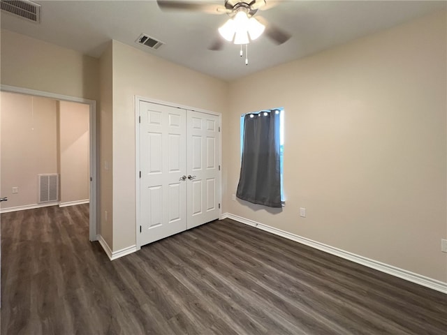 unfurnished bedroom with ceiling fan, dark hardwood / wood-style floors, and a closet