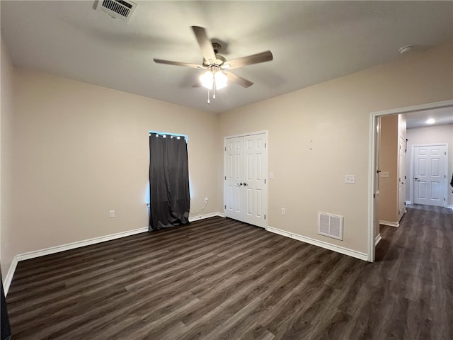 unfurnished room with dark wood-type flooring and ceiling fan