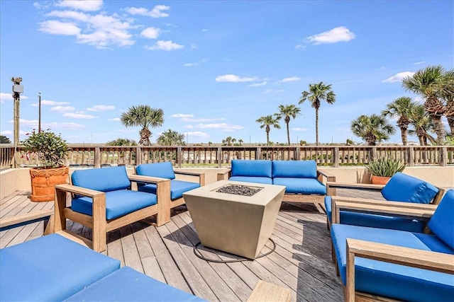 wooden terrace featuring an outdoor living space with a fire pit