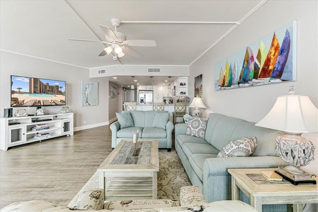living room with visible vents, crown molding, ceiling fan, and wood finished floors