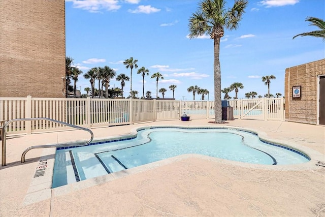community pool featuring fence and a patio