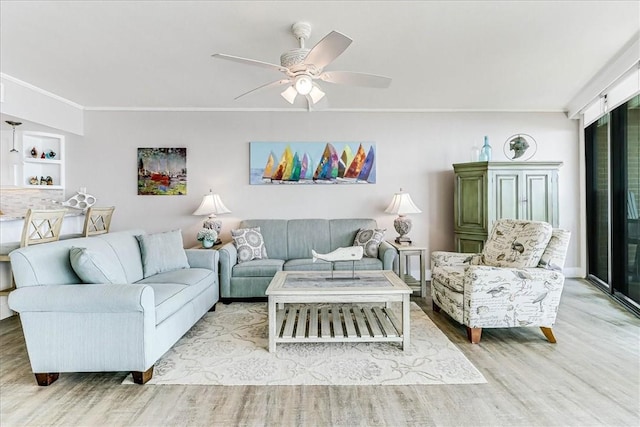 living room featuring crown molding, a ceiling fan, and wood finished floors