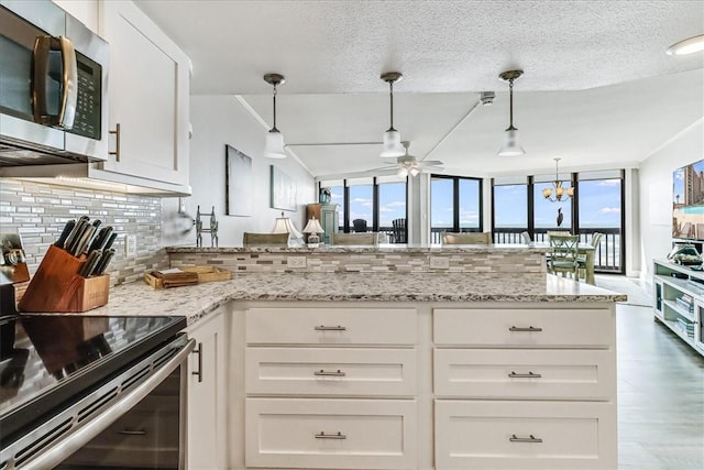 kitchen with decorative backsplash, a ceiling fan, a wealth of natural light, and stainless steel appliances