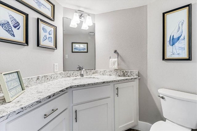 half bathroom featuring vanity and toilet