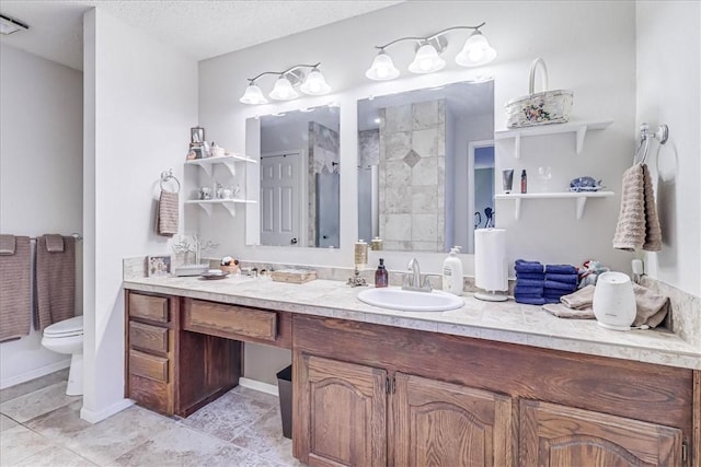 bathroom with a textured ceiling, vanity, toilet, and walk in shower