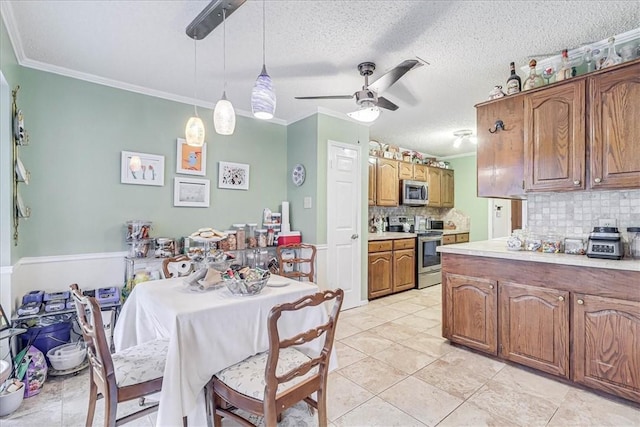 kitchen featuring appliances with stainless steel finishes, backsplash, ornamental molding, ceiling fan, and hanging light fixtures