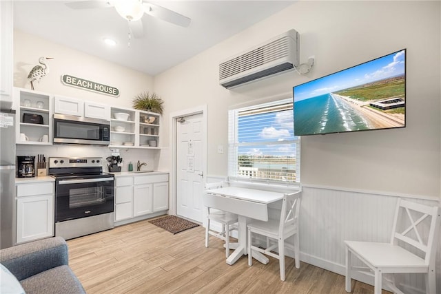 kitchen featuring stainless steel appliances, white cabinetry, sink, and light hardwood / wood-style floors