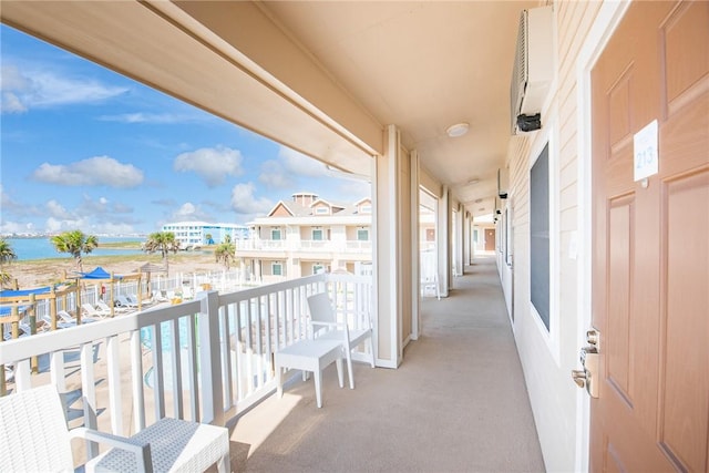 balcony with an AC wall unit and a water view