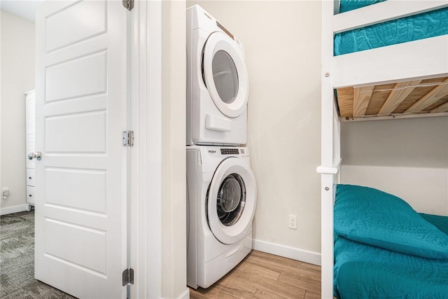 washroom featuring light wood-type flooring and stacked washing maching and dryer