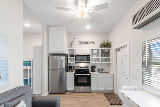 kitchen featuring white cabinetry, stainless steel appliances, sink, and light hardwood / wood-style flooring