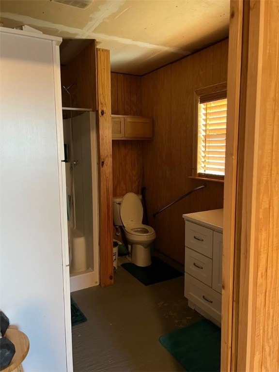 bathroom with toilet and wood walls