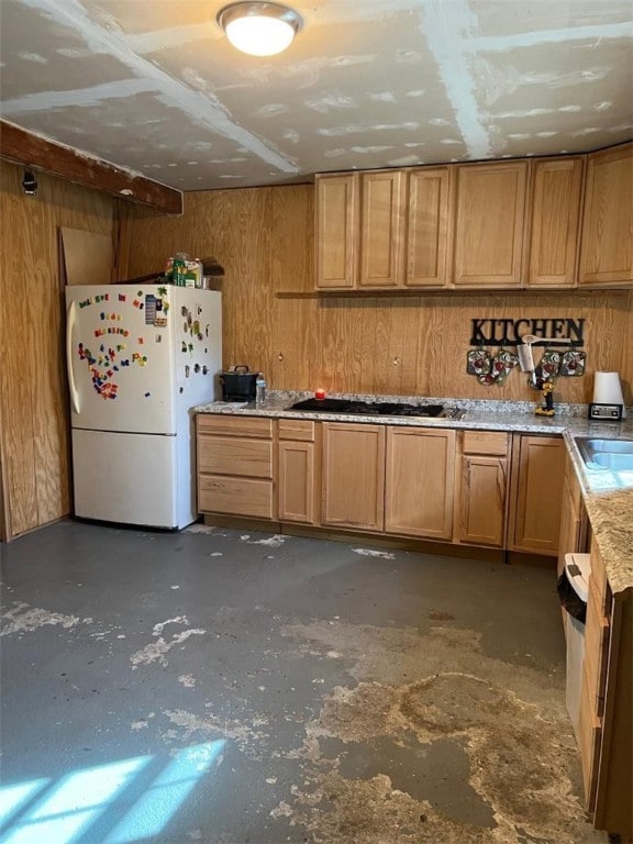 kitchen featuring wooden walls, stainless steel gas cooktop, and white fridge