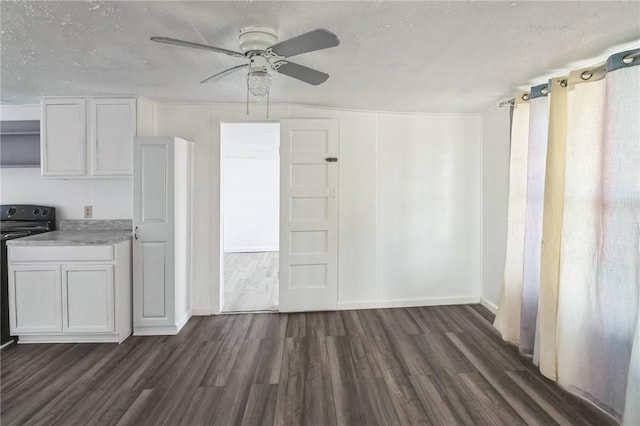 interior space featuring white cabinets, stove, dark hardwood / wood-style floors, and ceiling fan