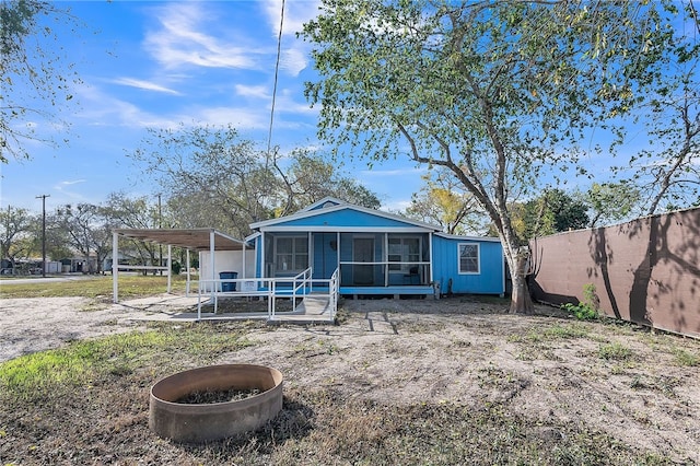 rear view of house with a carport and a sunroom