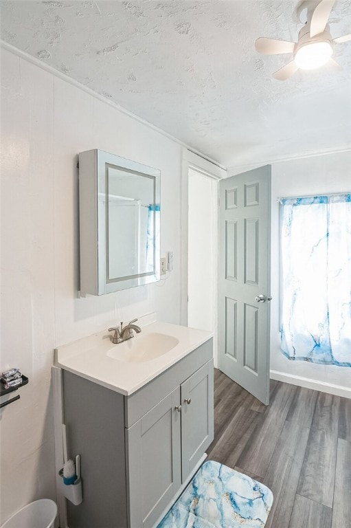 bathroom with hardwood / wood-style flooring, ceiling fan, a textured ceiling, and vanity