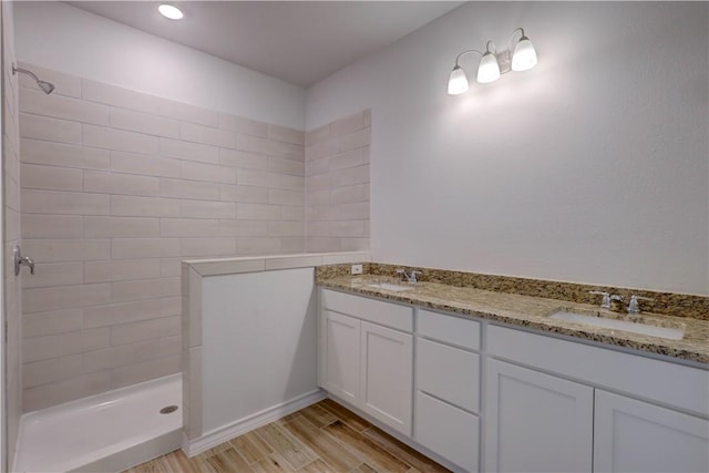 bathroom featuring tiled shower and vanity