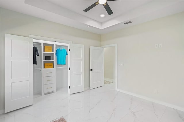 unfurnished bedroom with recessed lighting, marble finish floor, baseboards, and a tray ceiling