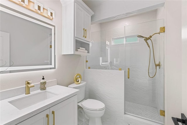 full bath featuring a marble finish shower, toilet, and vanity